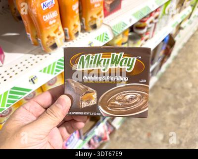 Los Angeles, California, United States - 08-14-2024: A view of a hand holding a package of Milky Way pudding and pie filling, at the store. Stock Photo