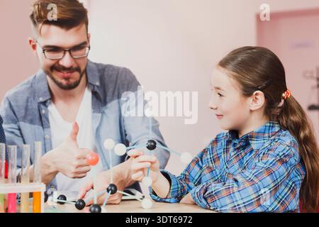 Child Learns About Molecules From a Teacher in a Classroom Setting During a Science Lesson Stock Photo