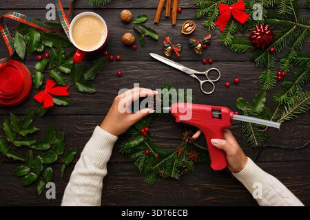 Making a Christmas Wreath With a Hot Glue Gun and Decorations at Home During the Holiday Season Stock Photo