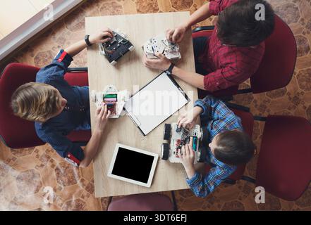 Students Working on Robotics Projects at a Table During an Educational Session Stock Photo