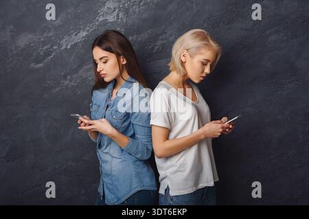 Collection of Two Young Women Using Smartphones in a Modern Space Stock Photo