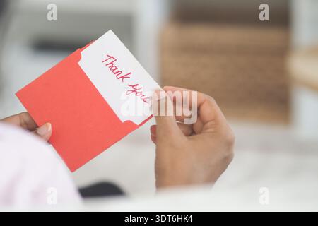 Holding a thank you card in a home setting Stock Photo