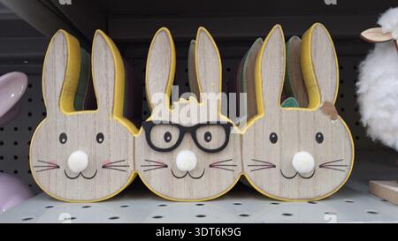 Niagara Falls, ON, Canada - February 15, 2026: Three wooden bunnies decoration with glasses are on the shelf for Easter. Stock Photo