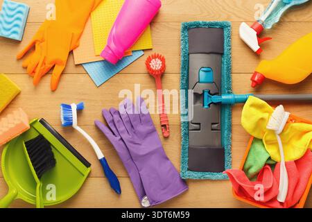 Cleaning Supplies and Tools Arranged in a Collage on a Wooden Surface for a Cleaning Activity Stock Photo