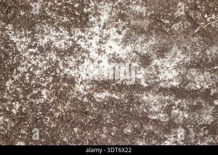 Rough gray textured background resembling weathered cement, featuring diagonal scratch patterns, granular surface details, uneven tones, and rugged st Stock Photo