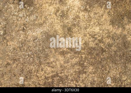Rough earthy textured background resembling weathered stone, featuring brown and beige tones, irregular stains, granular surface, and rustic aged appe Stock Photo