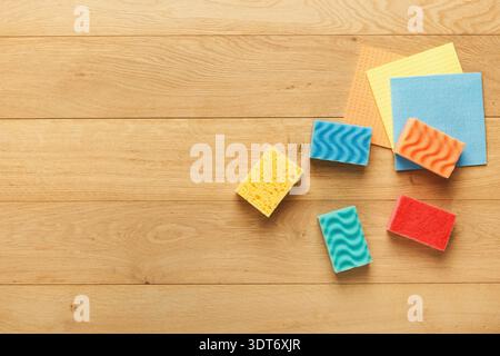 Mosaic of Colorful Sponges and Paper on Wooden Surface in a Casual Workspace Setting Stock Photo