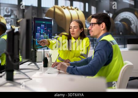 Engineers Operating Multiple Screens At Power Plant In Desktop Computer Stock Photo
