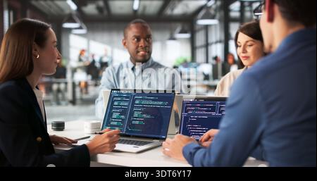 Diverse Group Of Engineers Collaborating On Software Development In Office. Stock Photo