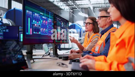 Engineers And Operator Meet In Modern Control Room For Maintenance Stock Photo