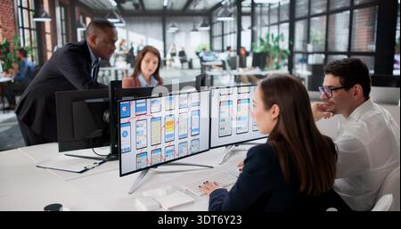 Diverse Team Of Young Professionals Developing Websites On Computer Screens. Stock Photo
