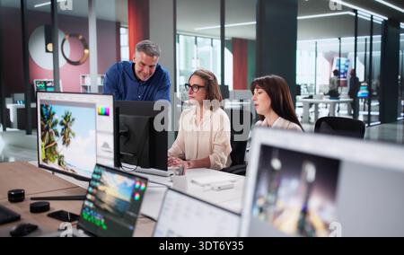 Creative Team Meeting: Graphic Designers Editing Photos For Web Use Stock Photo