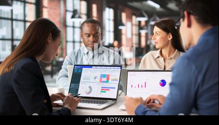 Analyzing Financial Reports On Personalized Data Analytics Dashboard During Team Meeting. Stock Photo