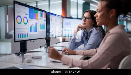 Diverse Women On Analytics Team Analyzing Financial Data At Office. Stock Photo