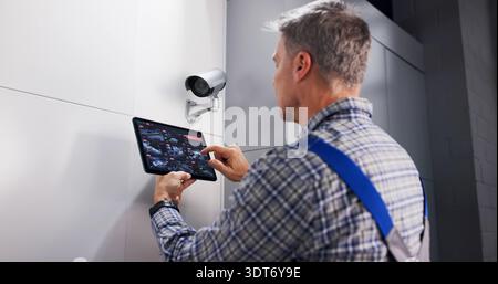 Skilled Technician Ensuring Safe Installation Of CCTV Surveillance System. Stock Photo