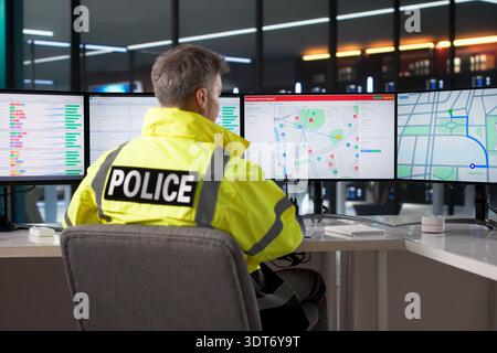Police Officer In Service Centre Monitoring Computer Screen For Traffic Stock Photo