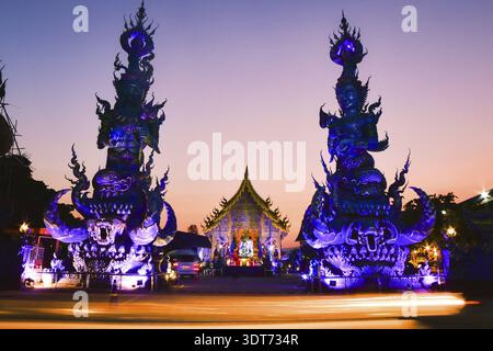 Panorama Blue Temple Wat Rong Suea Ten in Chiang Rai Thailand at sunset with colorful glowing sculptures and dramatic sunset blue orange sky Stock Photo