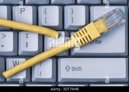 Internet connection disconnected. Blue computer keyboard with yellow network cable cutted off Stock Photo