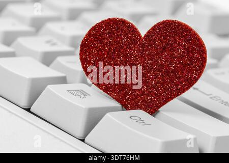 Single red heart on computer keyboard. Internet dating concept Stock Photo
