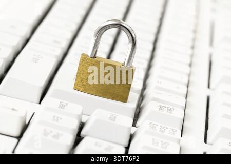 Security concept with metal padlock on computer keyboard. Safety of personal data concept with golden padlock on the computer keyboard Stock Photo