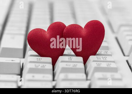 Small red hearts on keyboard. Internet dating concept Stock Photo