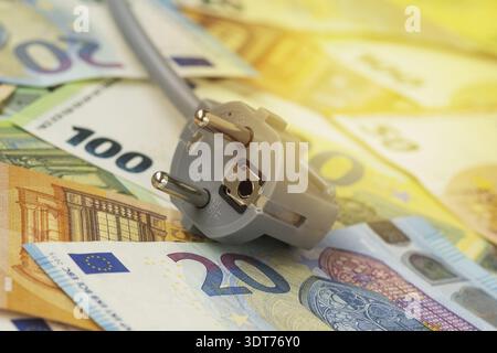 Electric plug on euro banknotes. Increasing of electricity cost for residential customers and business users. Payment of electricity bills. Rise in el Stock Photo