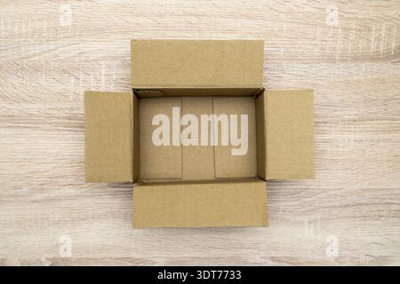 Empty open rectangular cardboard box on the wooden table. Top view Stock Photo