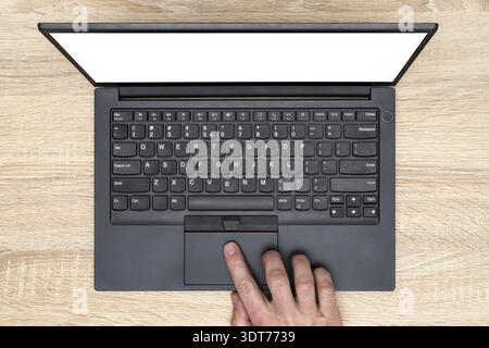 Hand working on a computer touchpad. A man is working by using a laptop computer on wooden table. Top view, business office workplace Stock Photo