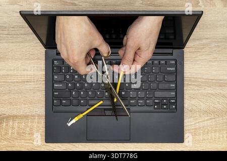 Network restrictions or censorship concept. Internet censor cutting a yellow network cable Stock Photo