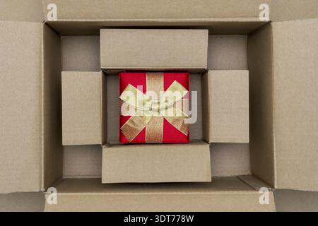 Opened large cadboard box with red gift box inside Stock Photo