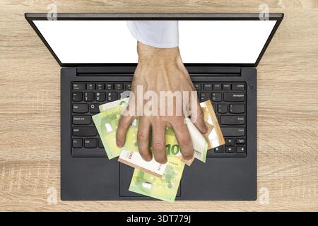 Hand reaching out of laptop screen to steal money. Stealing a money through a laptop, concept for computer hacker, network security and electronic ban Stock Photo