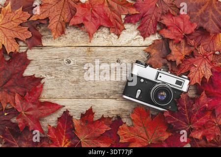 Old camera and red autumn leaves, top view Stock Photo