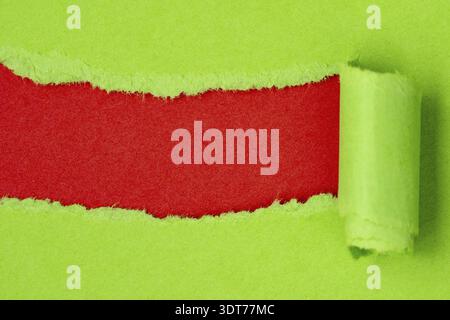 Green paper torn to reveal red copy-space ideal for your text Stock Photo