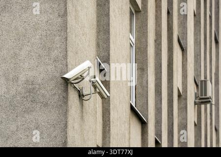 Two CCTV cameras on grey building wall. CCTV security system Stock Photo