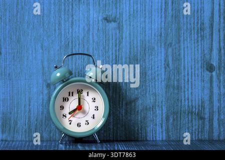 Old fashioned alarm clock on the blue wooden shelf. Copy-space Stock Photo