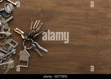 Collection of Keys and Keychains Spread out on a Wooden Table in a Casual Setting Stock Photo