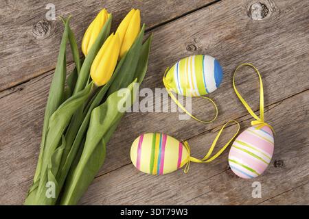 Three yellow tulips and three Easter eggs Stock Photo