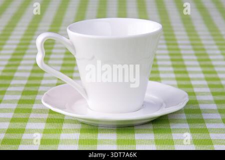 Empty cup on the checkered tablecloth texture Stock Photo