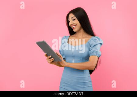 Cheerful young woman using tablet at studio Stock Photo
