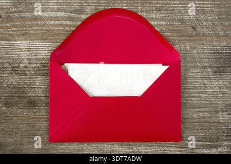 Opened red envelope with blank letter on wooden desk Stock Photo