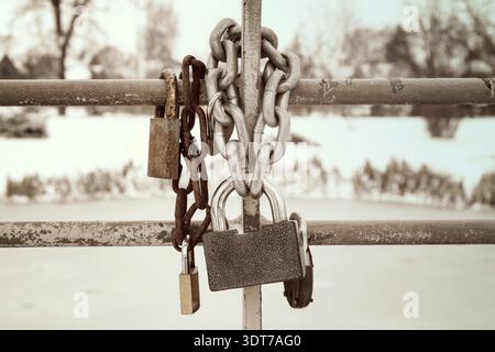 Old rusty padlocks hanging on metal chain Stock Photo
