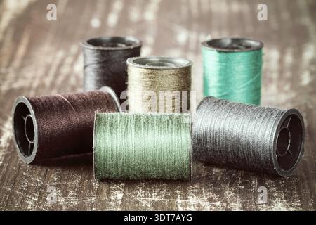 Bobbins with colorful threads on wooden background Stock Photo