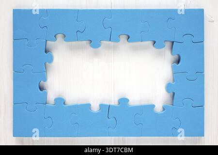 Blue puzzle frame on white wooden background Stock Photo