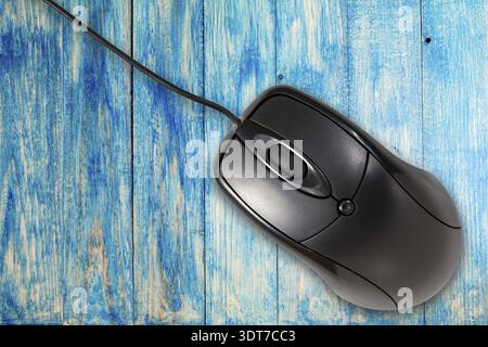 Black computer mouse on the blue wooden planks background Stock Photo