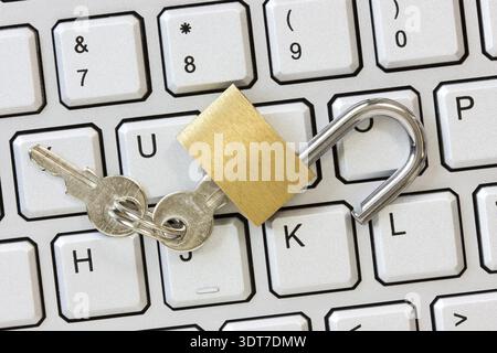 Unlocked padlock with a keys on the computer keyboard Stock Photo