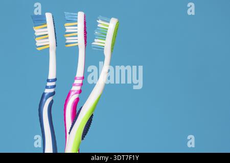 Three tooth brushes on the blue background Stock Photo