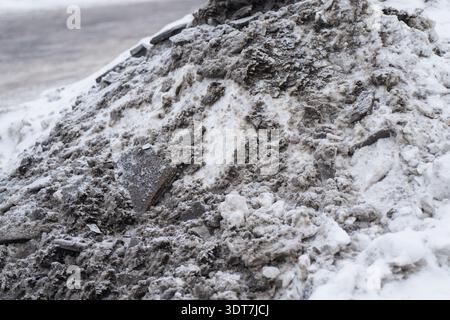 Urban snow heap with muddy ice and salt stained layers, detailed winter surface texture for climate, cleanup, and environmental concept backgrounds Stock Photo
