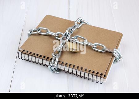 Padlock protects the notepad in a concept on protect the secret information Stock Photo