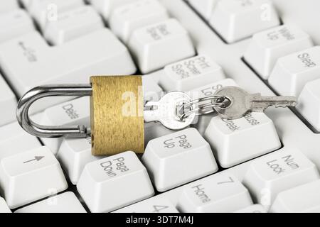 Security concept, open yellow padlock on white keyboard.Computer being protected from online cybercrime and hacking Stock Photo