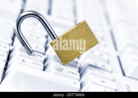Computer security break up. An unlocked padlock on top a computer keyboard to represent the concept of computer security breach Stock Photo